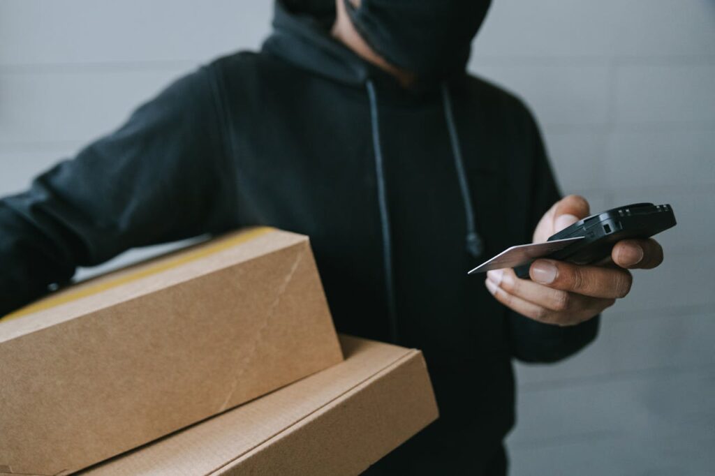 Close-up of a man using a mobile card terminal for delivery payment indoors.